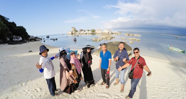 wisatawan sedang menikmati pemandangan Pantai di pulau kelayang dalam paket tur Belitung tanpa hotel